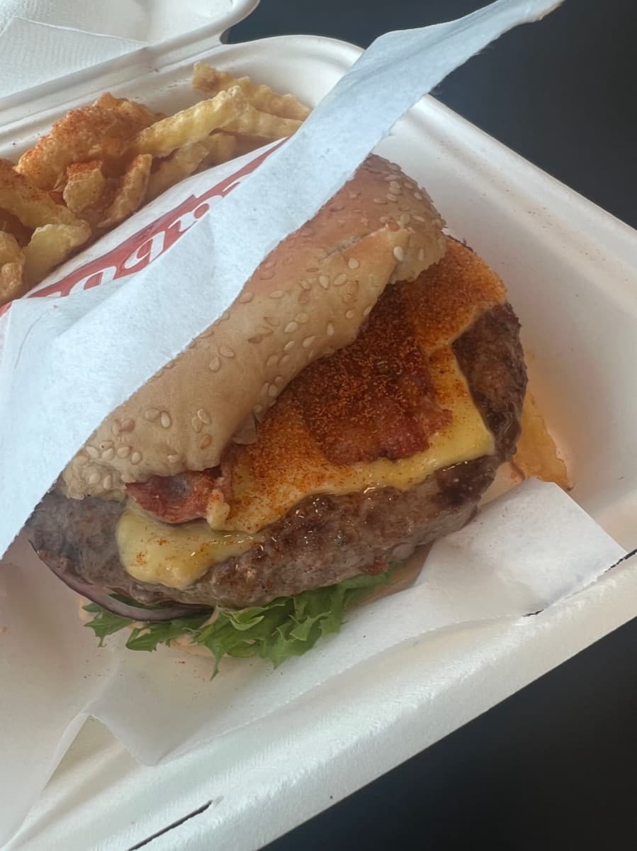Klassikeren i takeaway-boks: sesambrød, kjøtt, smeltet ost, bacon og et godt lag grillkrydder på toppen